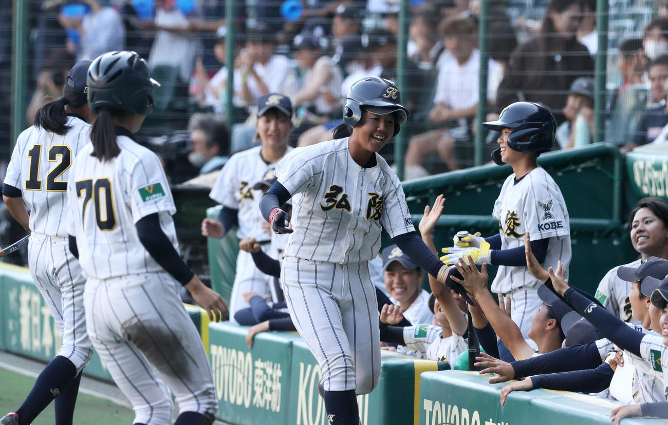 神戸弘陵対岐阜一　1回表神戸弘陵1死二、三塁、西上（手前）はスクイズを決めベンチのナインから祝福を受け笑顔を見せる（撮影・上山淳一）