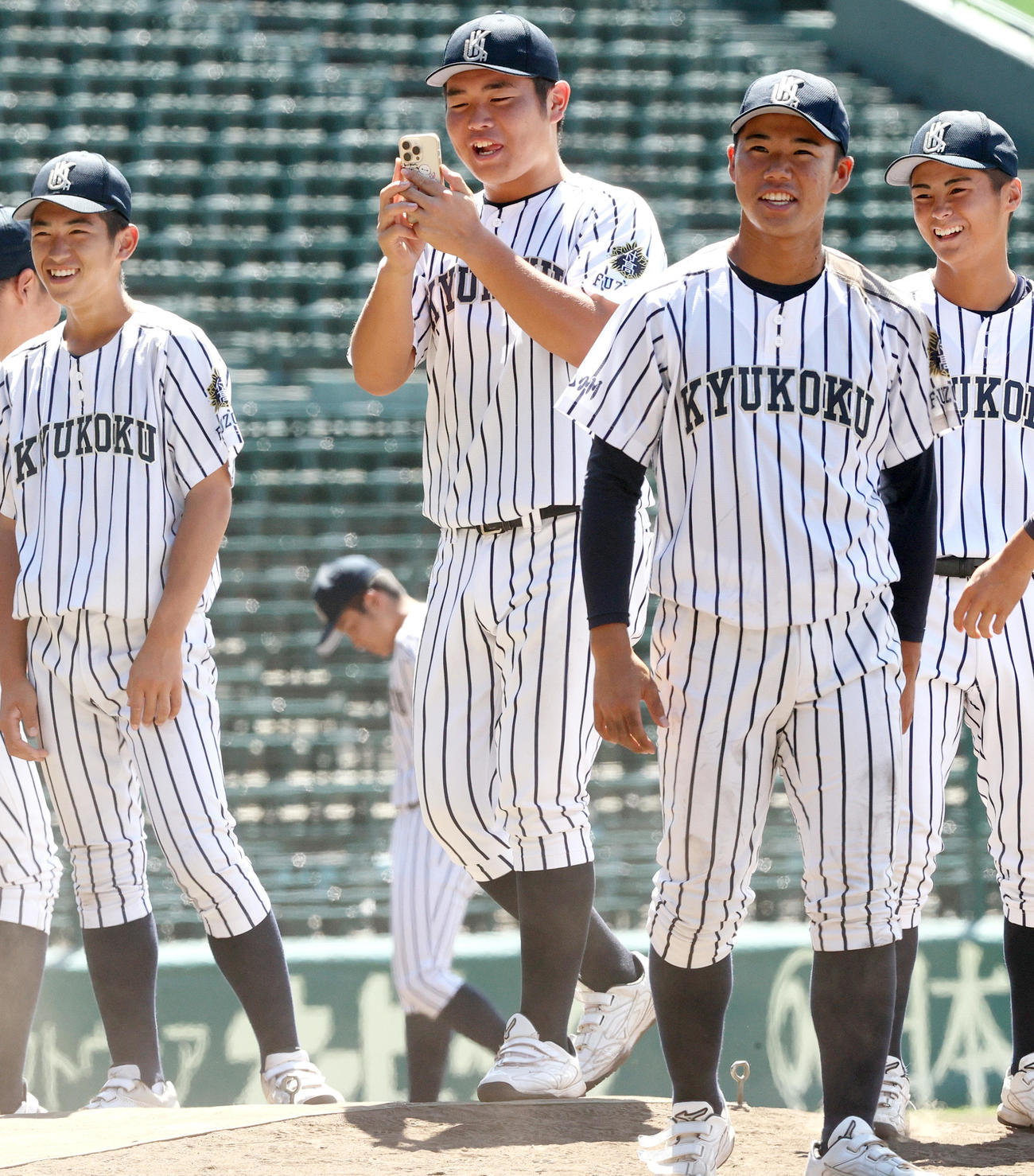 甲子園球場見学で仲間を撮影する九州国際大付の佐倉（左から2人目）（撮影・上山淳一）