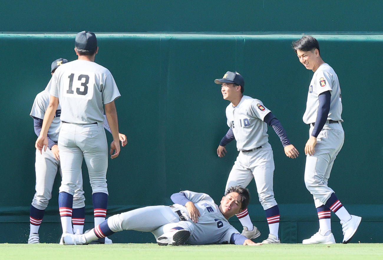 甲子園球場見学で外野の芝を確かめる慶応の清原（中央）（撮影・上山淳一）