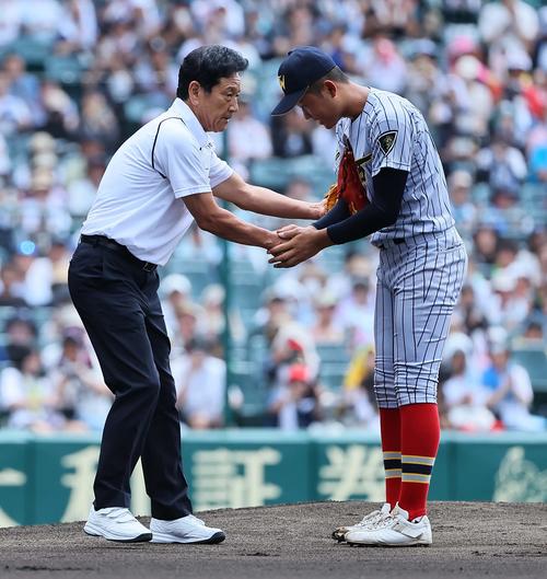 始球式を務めた栗山氏（左）は上田西先発の権田とあくしゅを交わす（撮影・上田博志）