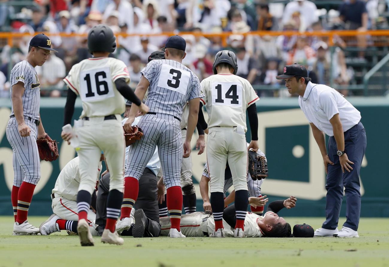土浦日大―上田西　6回裏を終えてベンチに引き揚げる際に倒れた土浦日大の中堅手香取（右下）（共同）