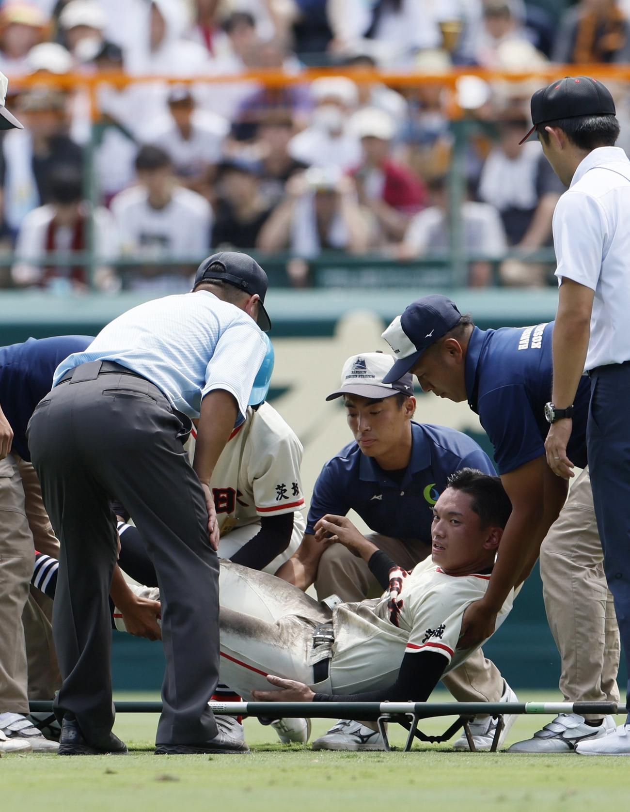 土浦日大―上田西　6回裏を終えてベンチに引き揚げる際に倒れ、担架に乗せられる土浦日大の中堅手香取（下）（共同）