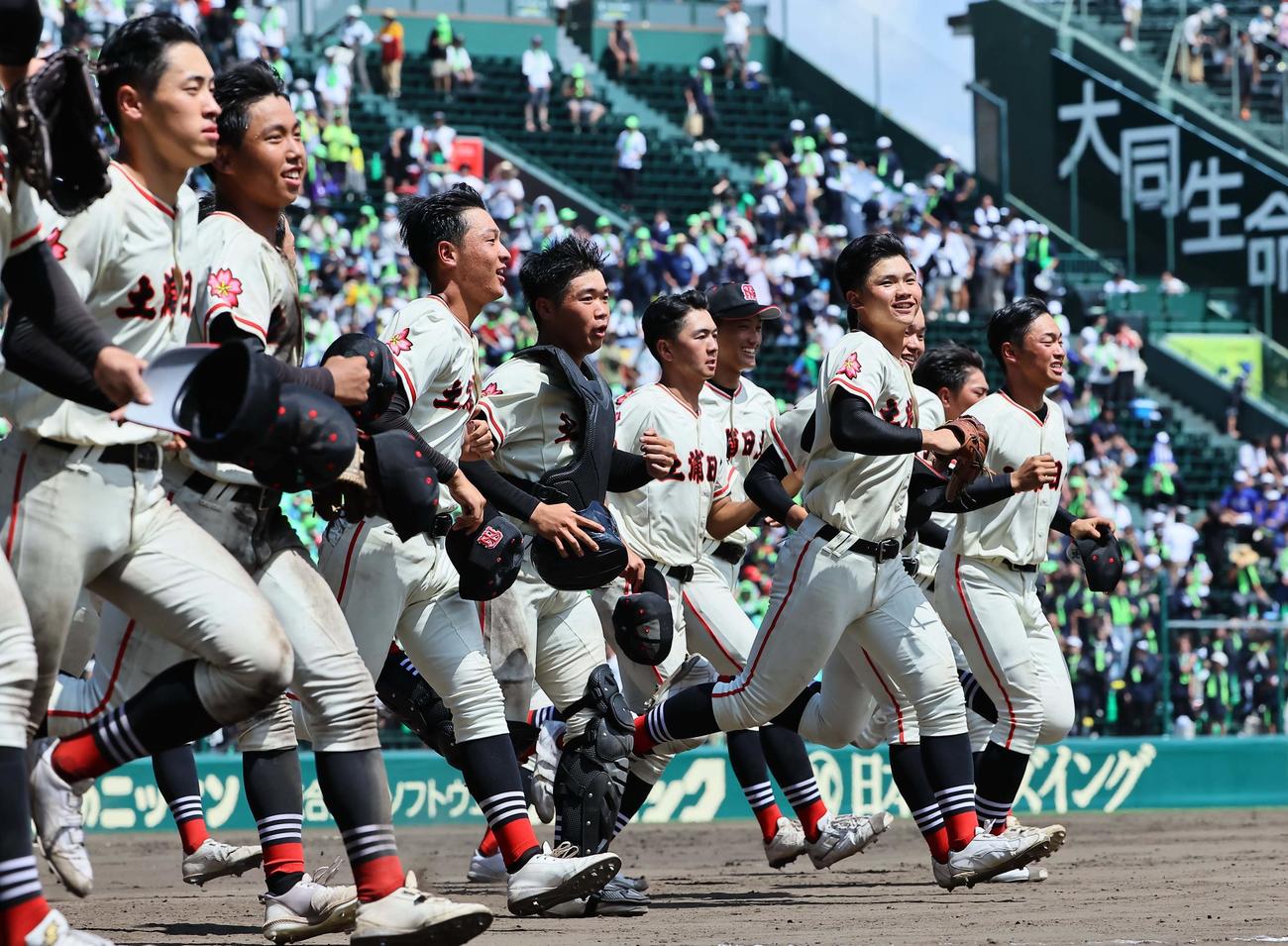 土浦日大対上田西　初戦を突破した土浦日大ナインはアルプス応援団席に元気よく駆けだす（撮影・上田博志）