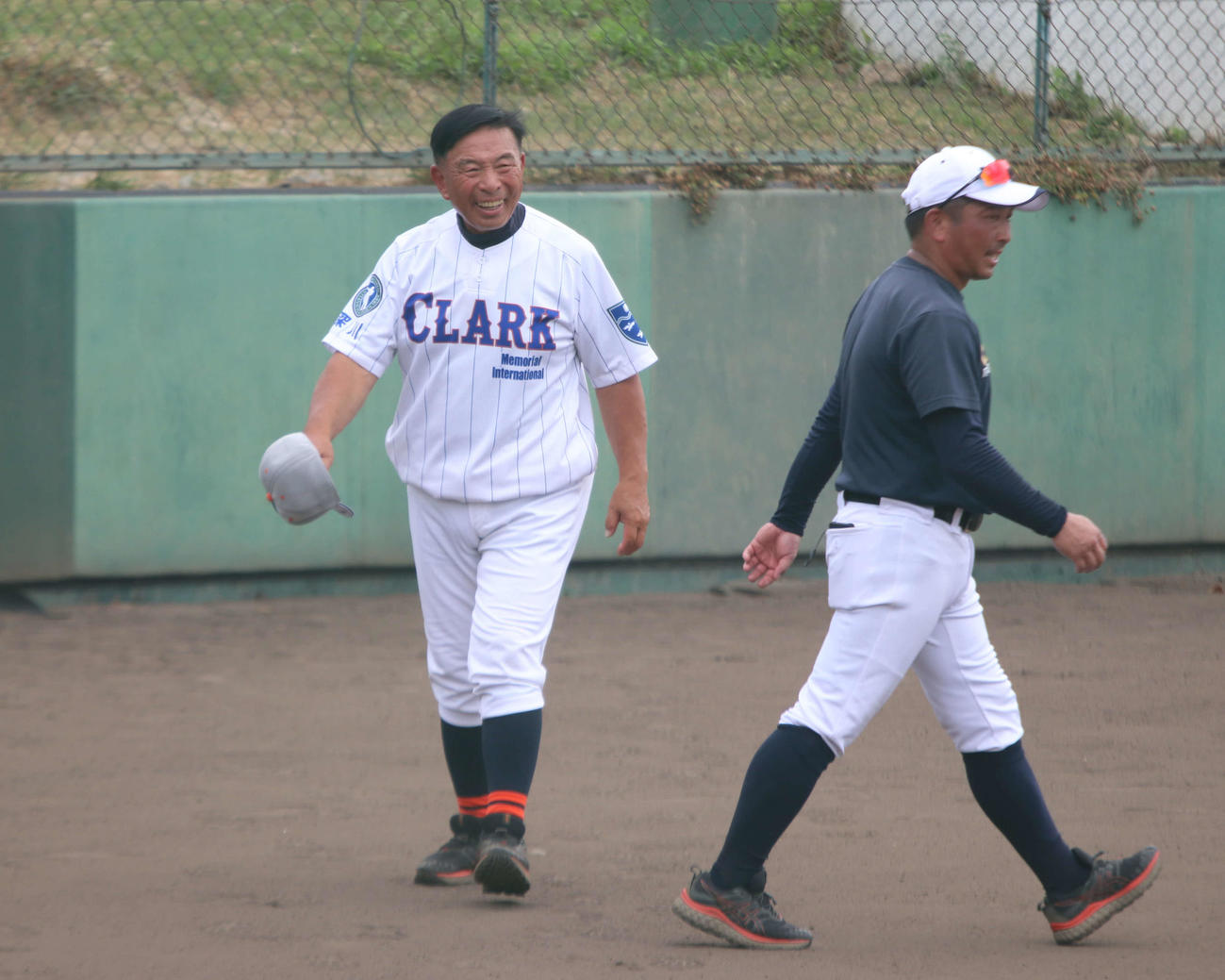 グラウンドを歩くクラークの佐々木監督（左）（撮影・山崎純一）