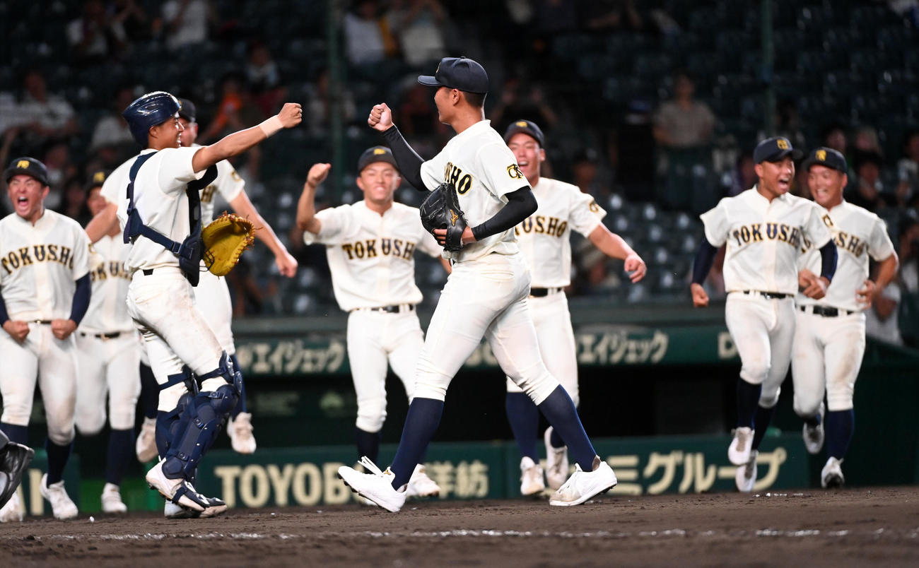 　愛工大名電に完投勝利の徳島商・森煌誠（中央右）は捕手の真鍋とグータッチを交わす（撮影・前岡正明）