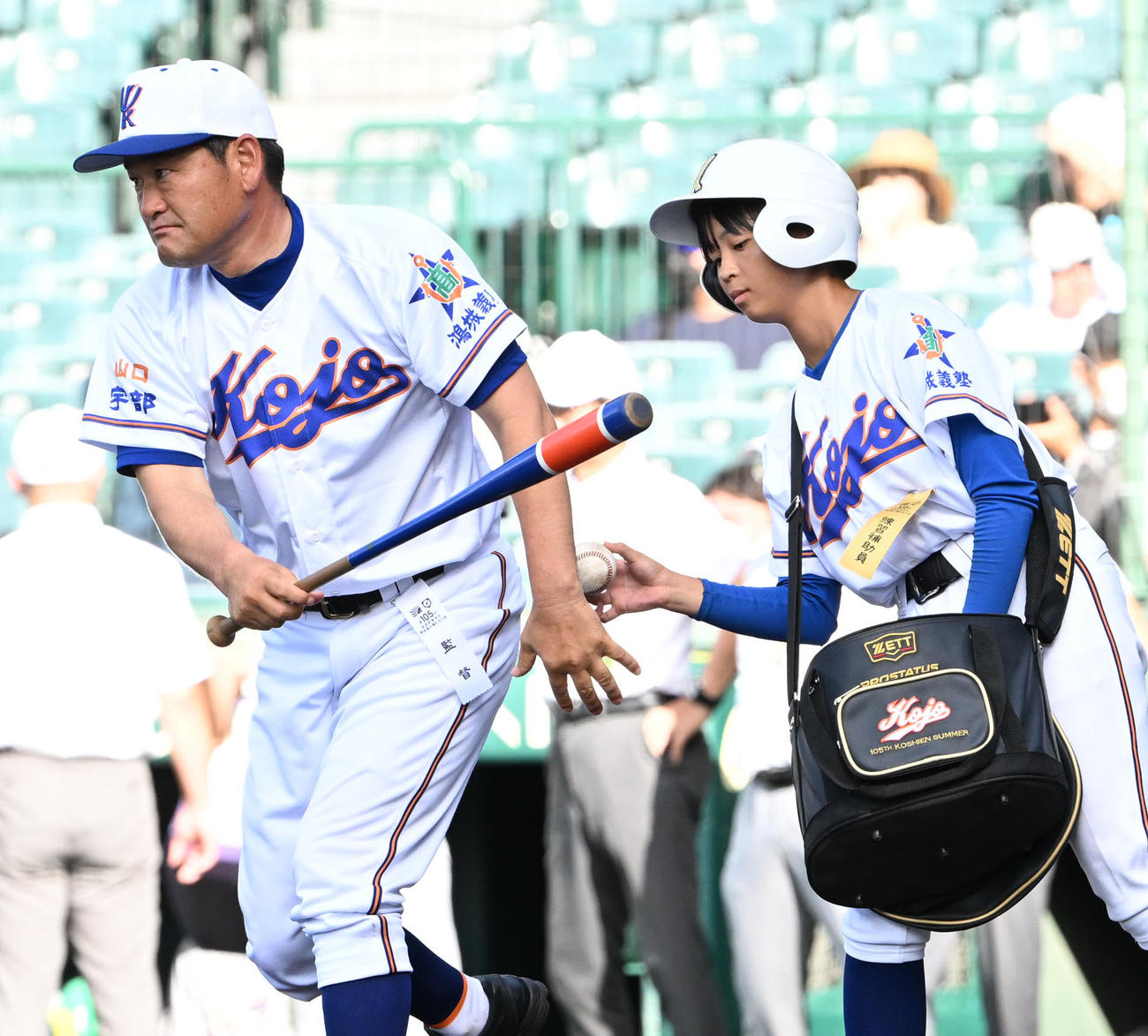 花巻東対宇部鴻城　ユニホームを着用しノックの補助を行う宇部鴻城・岡野美和（右）。左は宇部鴻城・尾崎公彦監督（撮影・石井愛子）