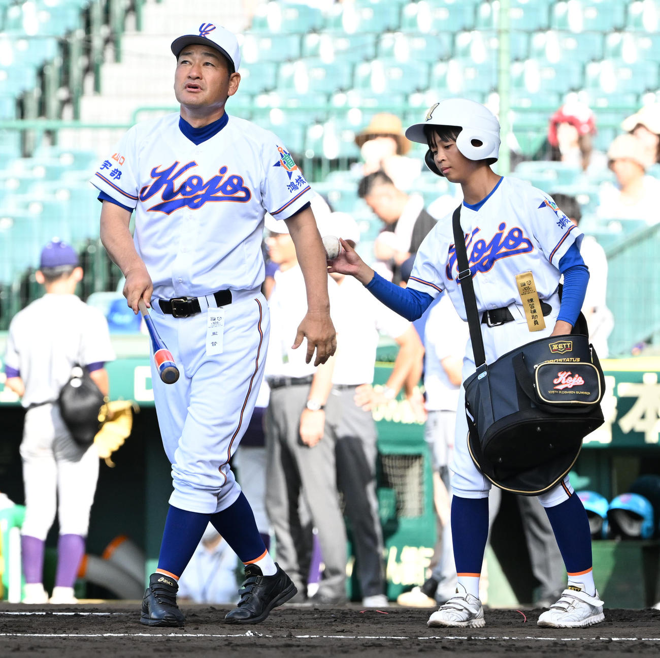 花巻東対宇部鴻城　ユニホームを着用しノックの補助を行う宇部鴻城・岡野美和（右）。左は宇部鴻城・尾崎公彦監督（撮影・石井愛子）