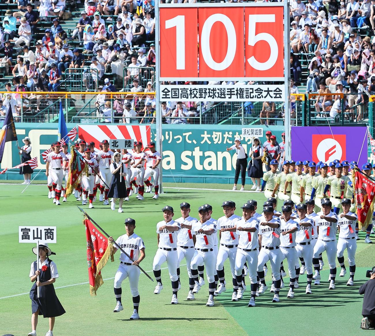 6日、全国高等学校野球選手権大会開会式で甲子園球場のグラウンドを行進する富山商ナイン