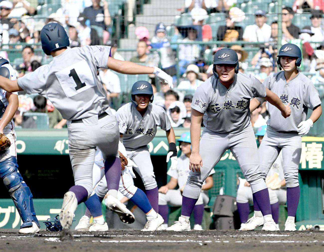 宇部鴻城対花巻東　4回裏花巻東1死二、三塁、佐々木麟（右から2人目）は広内の適時打で本塁突入する北條にスライディングの合図を送る（撮影・石井愛子）