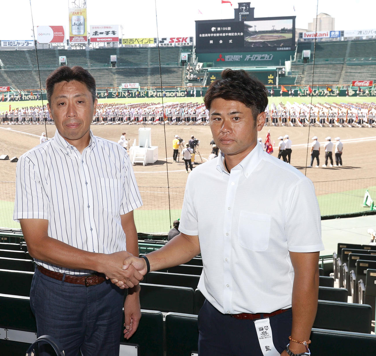 甲子園球場で握手をかわす北海の平川監督（左）と明豊の川崎監督（撮影・上山淳一）
