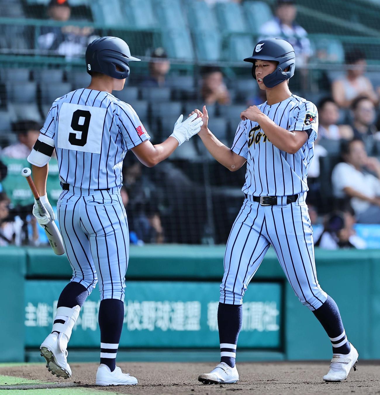 東海大熊本星翔対浜松開誠館　1回表東海大熊本星翔1死三塁、渡嘉敷の遊ゴロで生還した百崎（右）は中島淳惺とハイタッチをする（撮影・上田博志）