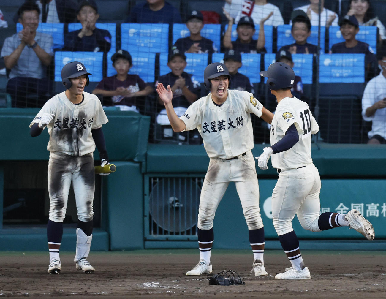 文星芸大付対宮崎学園　8回表文星芸大付無死一、三塁、右前に適時打を放ち相手失策の間に生還しナインに出迎えられる工藤（撮影・藤尾明華）