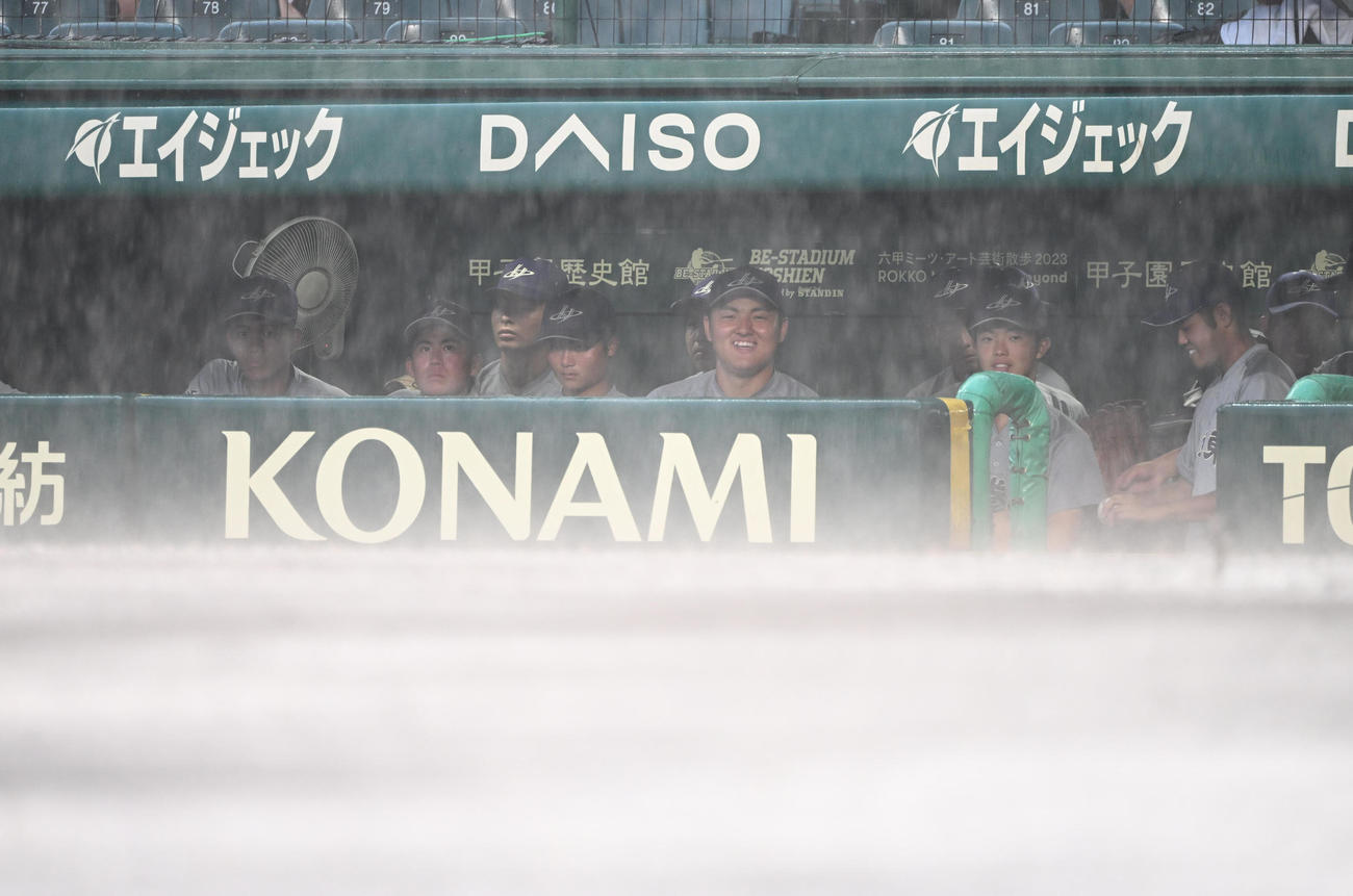 クラーク対花巻東　8回表途中、突然の雷雨にベンチで苦笑いを浮かべる花巻東・佐々木麟ら（撮影・和賀正仁）