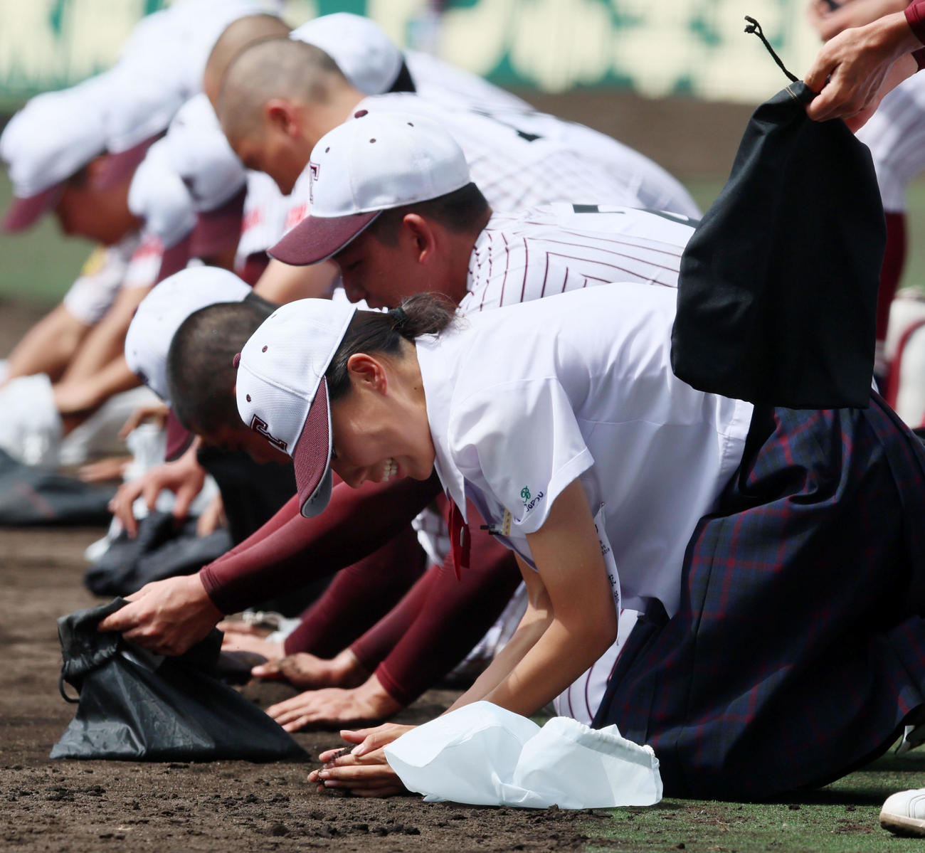 鳥栖工対日大三　日大三に敗れ甲子園の土をナインとともに集める鳥栖工の女子マネジャー緒方美月さん（撮影・加藤哉）