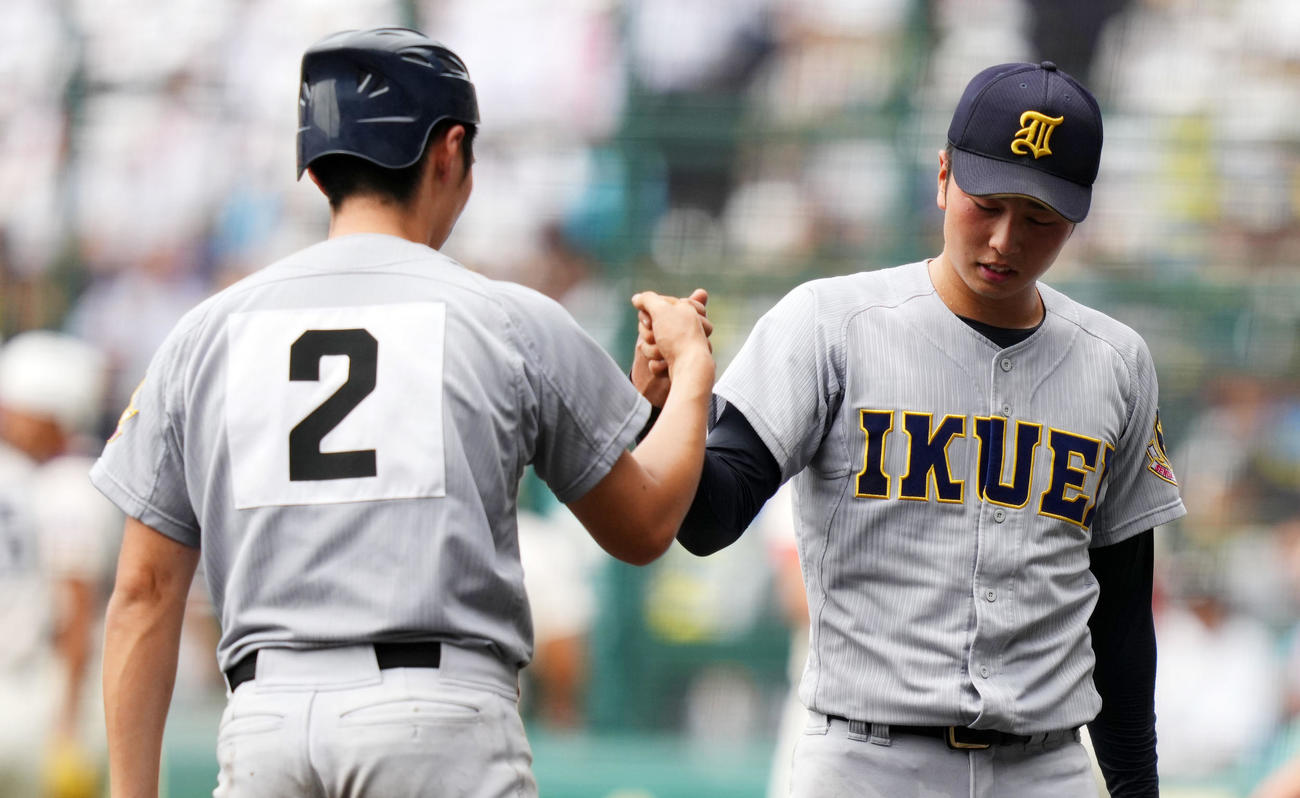仙台育英対履正社　試合を終えタッチを交わす仙台育英・高橋（右）と尾形（撮影・横山健太）