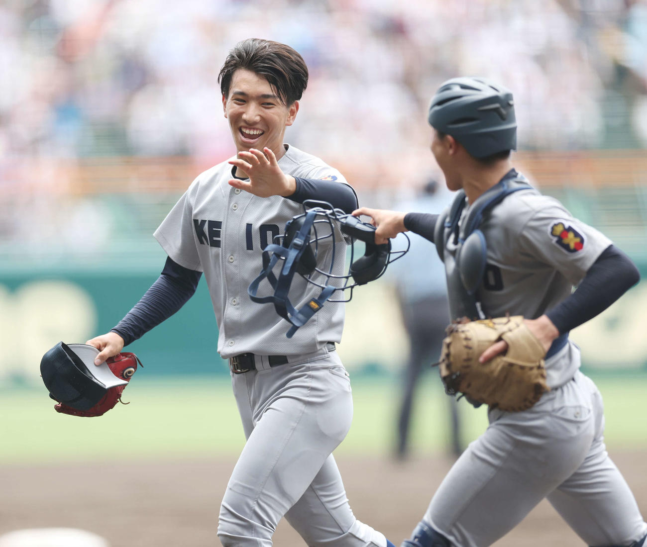 慶応対広陵　2回裏を無失点に抑え、慶応・渡辺憩（右）と笑顔でタッチする小宅（撮影・宮地輝）