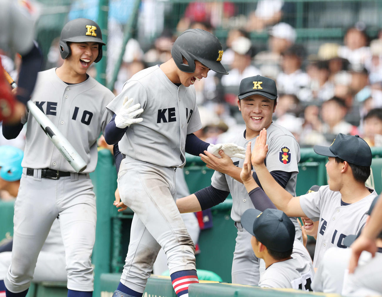 慶応対広陵　3回表慶応1死二、三塁、延末の二ゴロの間に生還し、チームメートと喜ぶ八木（左から2人目）（撮影・宮地輝）