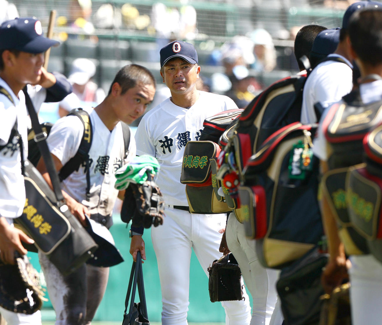 慶応対沖縄尚学　慶応に敗れた沖縄尚学の比嘉監督（中央）はベンチ前でナインに話しかける（撮影・上山淳一）