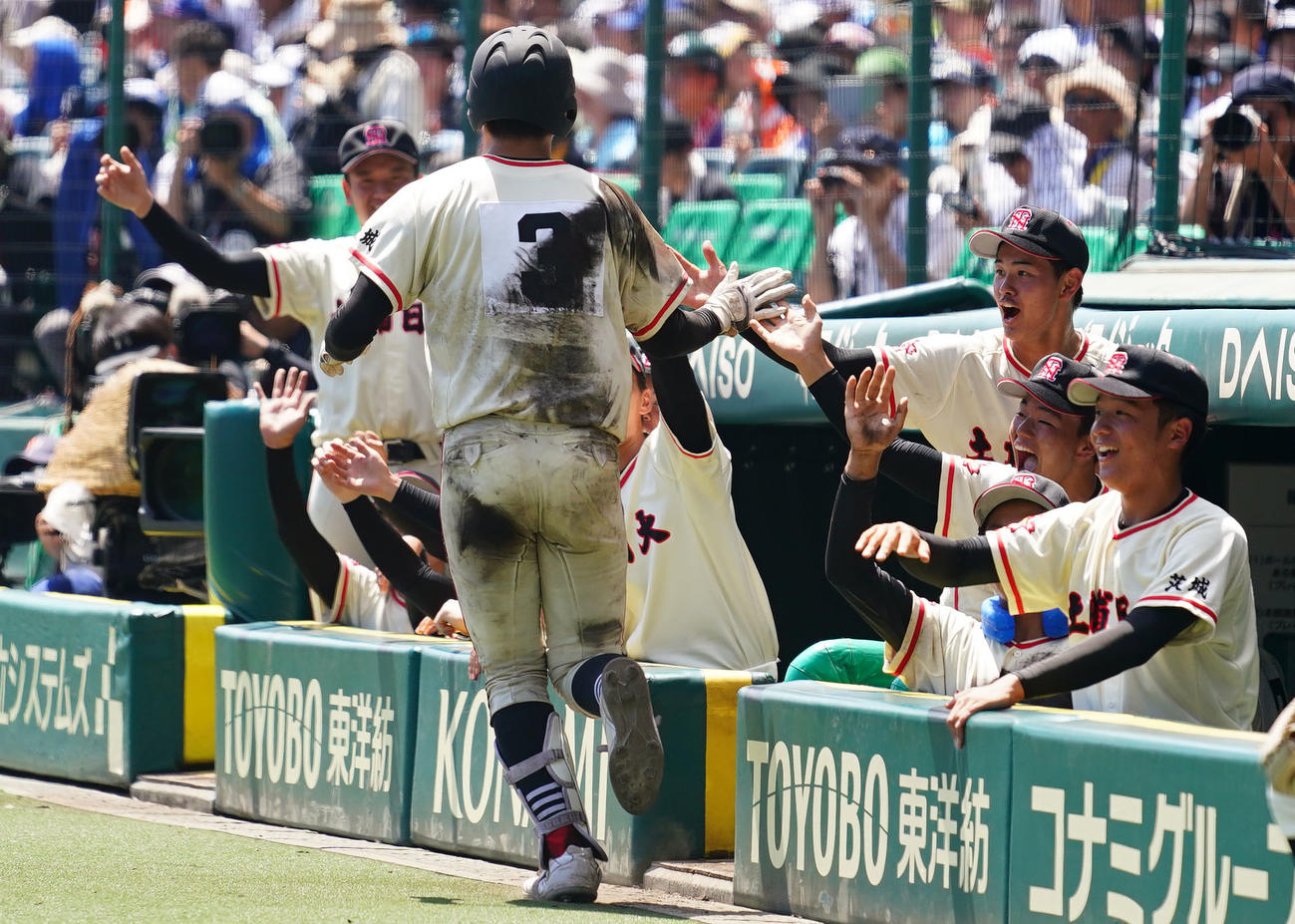 土浦日大対八戸学院光星　9回表土浦日大無死、中越え本塁打を放ち生還した松田とタッチを交わす土浦日大ナイン（撮影・横山健太）