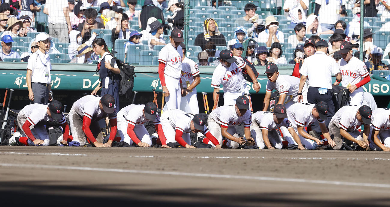 神村学園対おかやま山陽　神村学園に敗れ、土を拾うおかやま山陽ナイン（撮影・藤尾明華）