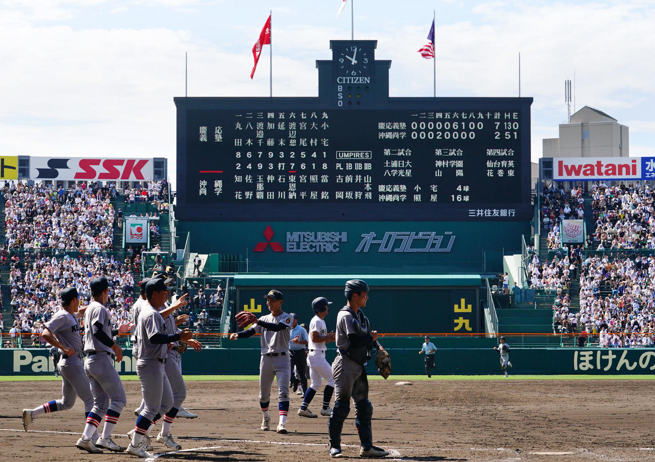 慶応対沖縄尚学　103年ぶりの夏の大会準決勝進出を決めタッチを交わす慶応ナイン（撮影・横山健太）