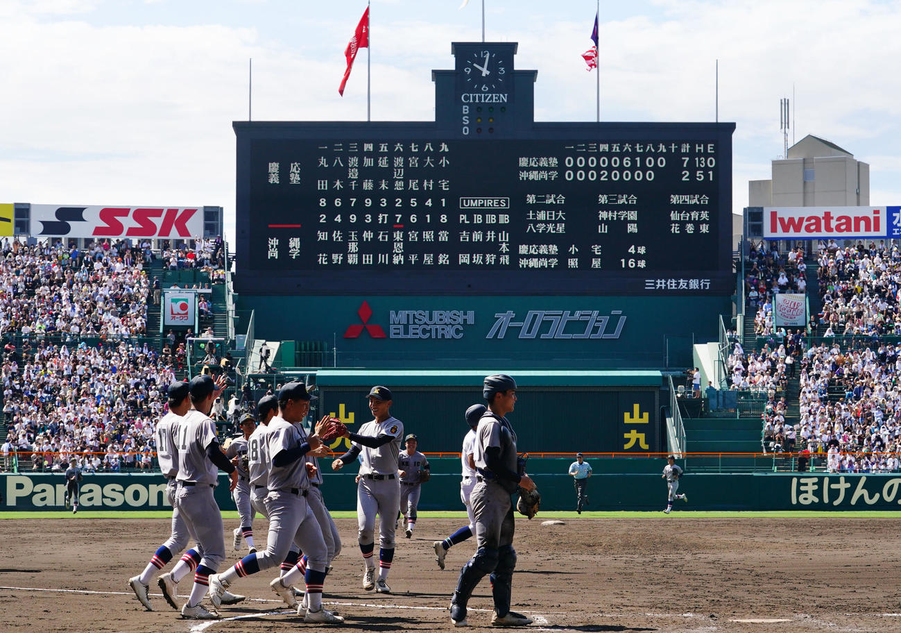 慶応対沖縄尚学　103年ぶりの夏の大会準決勝進出を決めタッチを交わす慶応ナイン（撮影・横山健太）