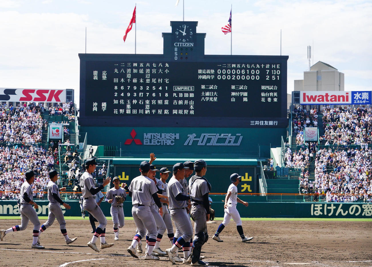 慶応対沖縄尚学　103年ぶりの夏の大会準決勝進出を決めタッチを交わす慶応ナイン（撮影・横山健太）