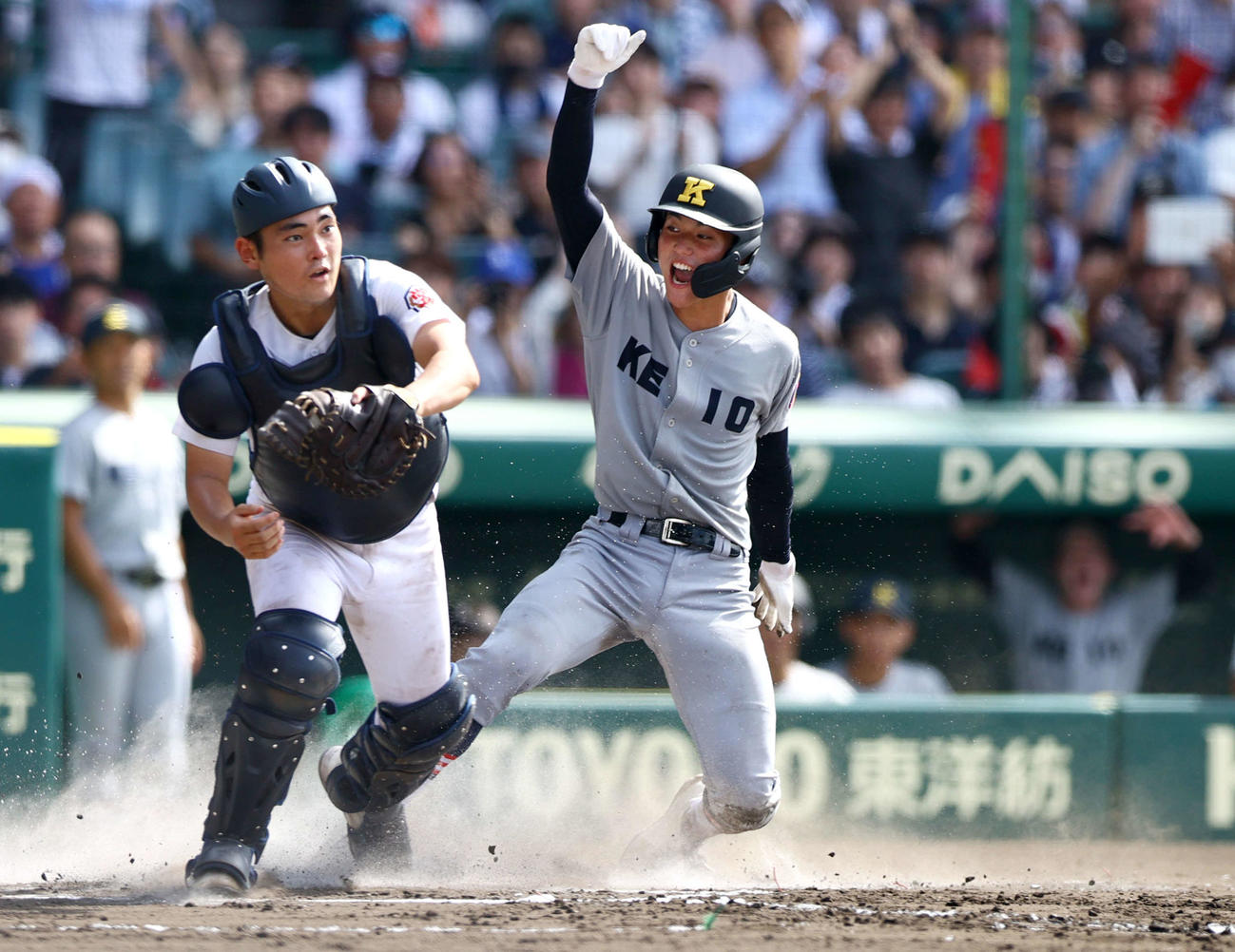 慶応対沖縄尚学　6回表慶応1死二塁、福井の右前適時打で再刊する渡辺憩（右）。捕手大城和（撮影・上山淳一）