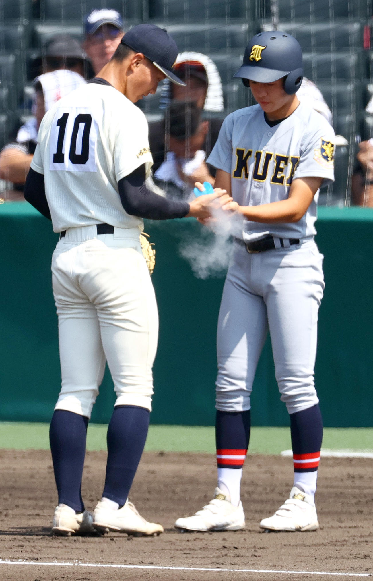 神村学園対仙台育英　仙台育英の三塁コーチャー伊藤（右）は投直を受けた神村学園・黒木の手をアイシングする（撮影・上山淳一）