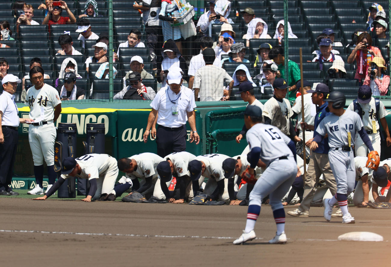 神村学園対仙台育英　仙台育英に敗れ、甲子園の土を拾う神村学園の選手たち（撮影・上山淳一）
