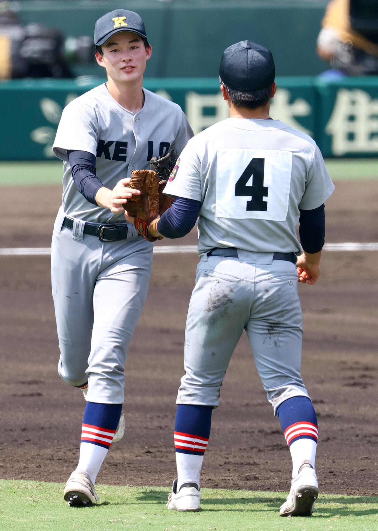 土浦日大対慶応　6回裏に右前適時打を放った大村（右）を祝福し7回の守備に向かう丸田（撮影・上山淳一）