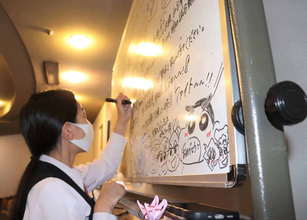 慶応ナインへ手書きのホワイトボードに思いをしたためる、宿舎スタッフの奥野花梨さん（撮影・中島麗）
