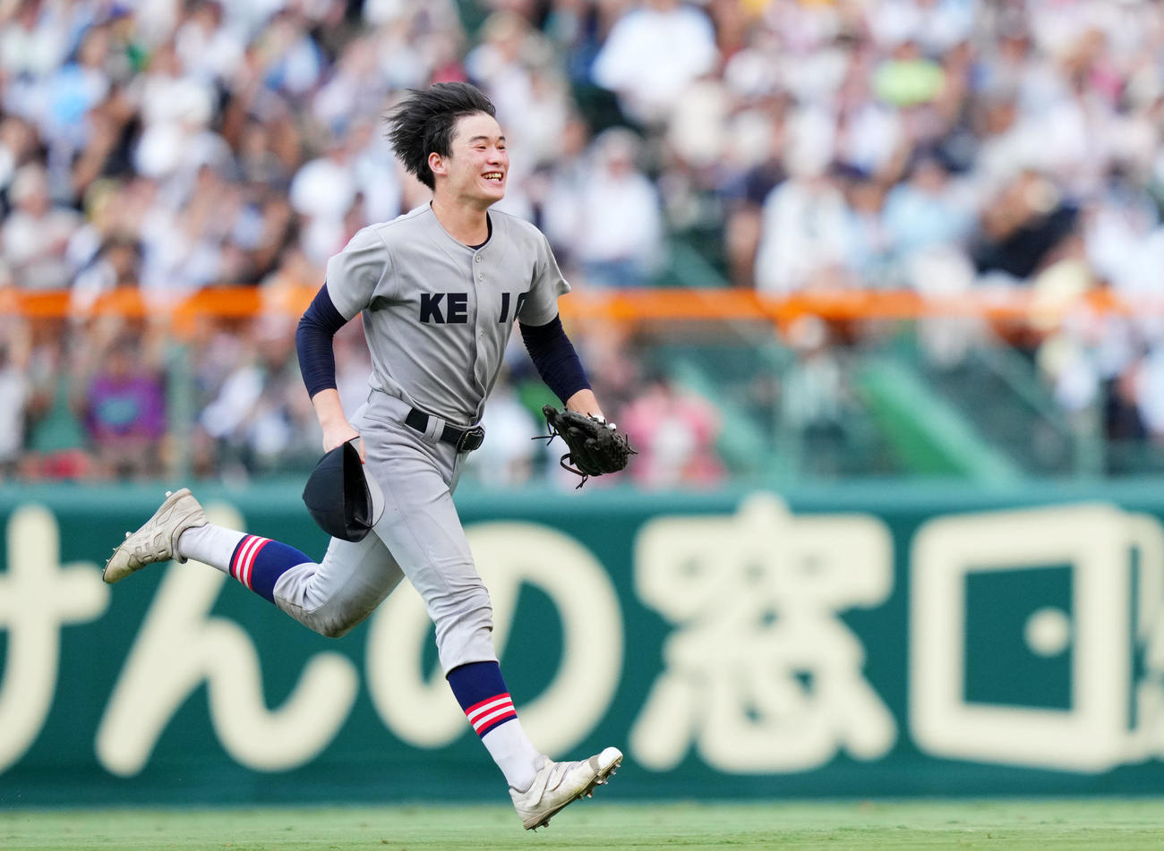 慶応対仙台育英　優勝を果たし笑顔で歓喜の輪へ向かう慶応・丸田（撮影・横山健太）