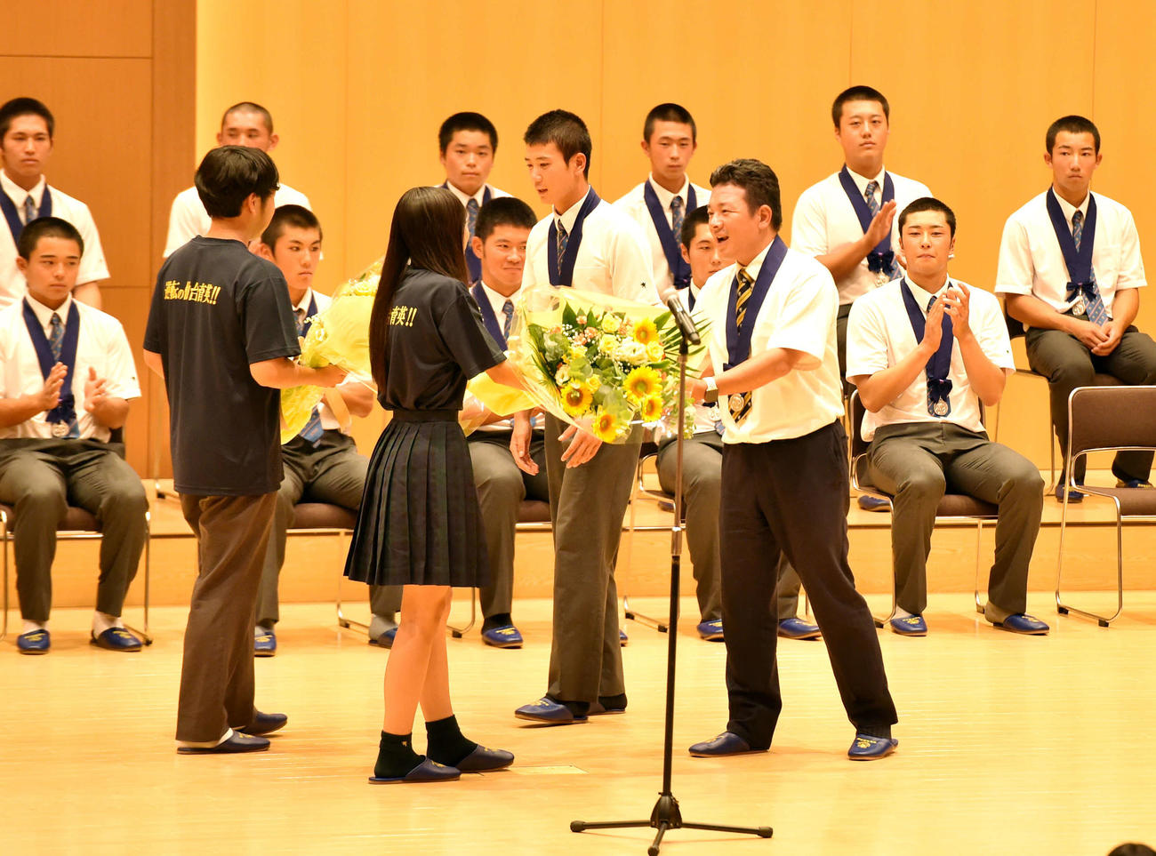 花束を受け取る仙台育英・山田（中央）と須江監督（撮影・相沢孔志）