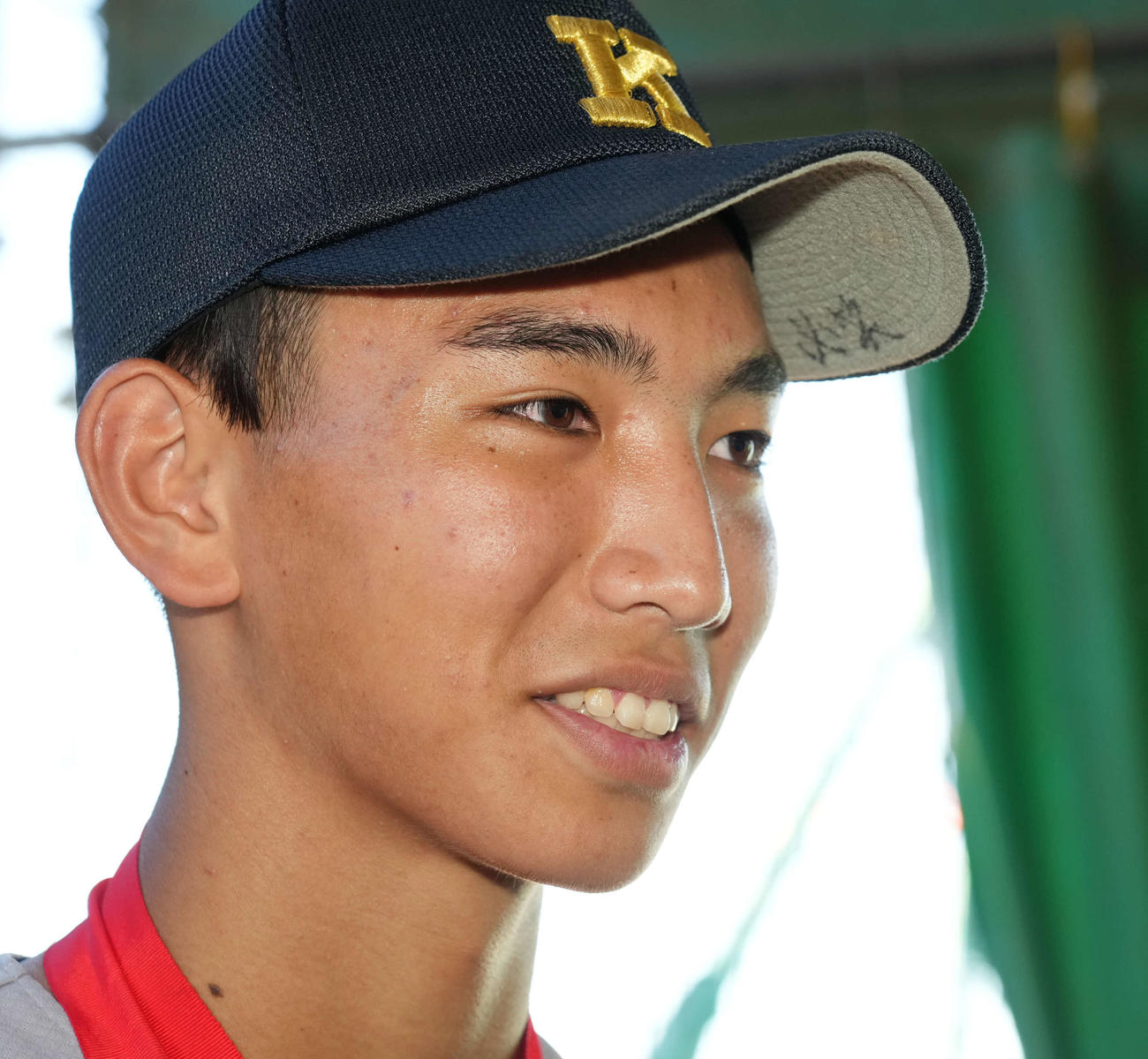 全国高校野球選手権大会で107年ぶりに優勝し地元凱旋（がいせん）後の囲み取材に臨む慶応・小宅。帽子のつばには「必笑」の文字が書かれていた（撮影・小沢裕）