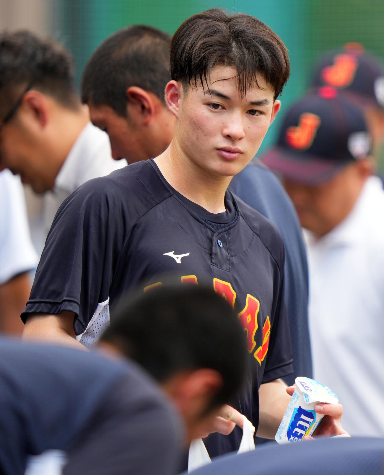 駒大対U18日本代表　U18日本代表・馬淵史郎監督からの差し入れアイスを手に取る丸田（撮影・横山健太）