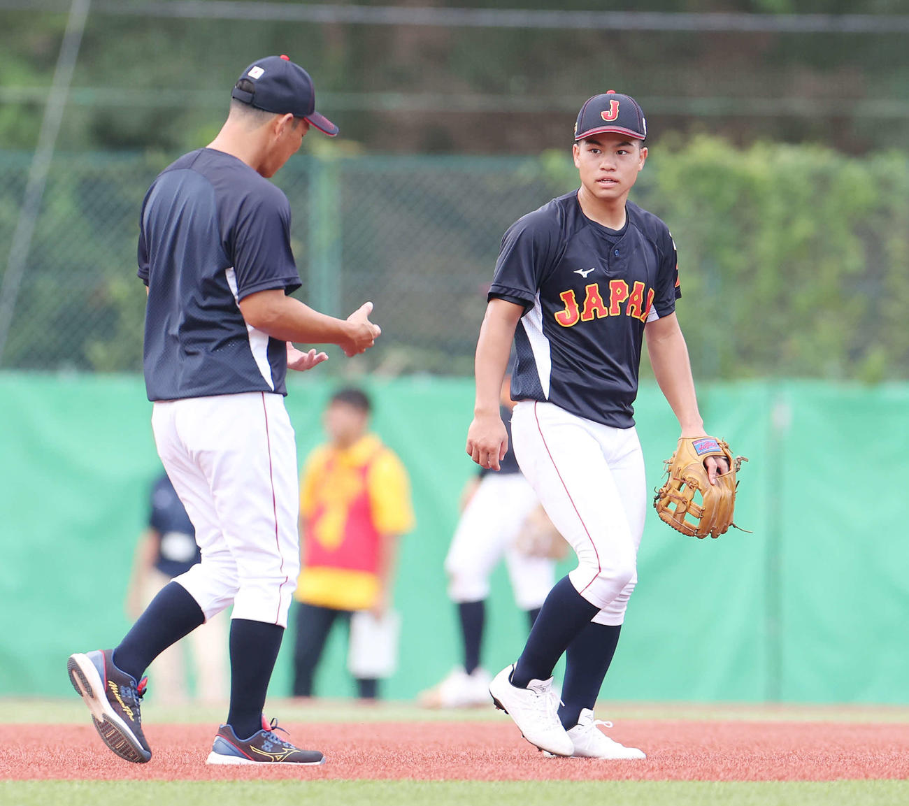 U12日本代表の井端監督（左）のアドバイスを受ける緒方（撮影・宮地輝）