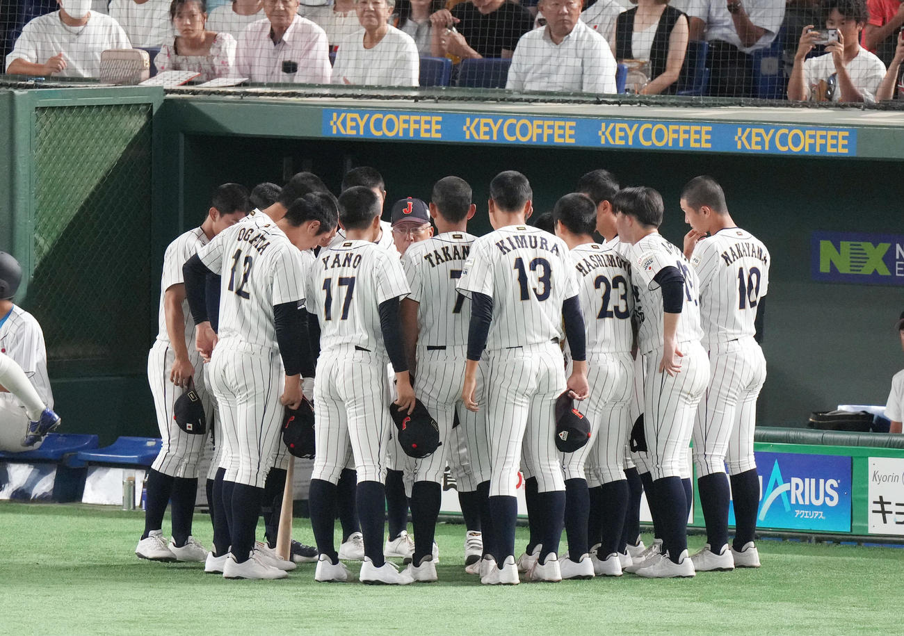 高校日本代表対大学日本代表　1回裏を終え、円陣を組み話をする馬淵監督（後方中央）（撮影・狩俣裕三）