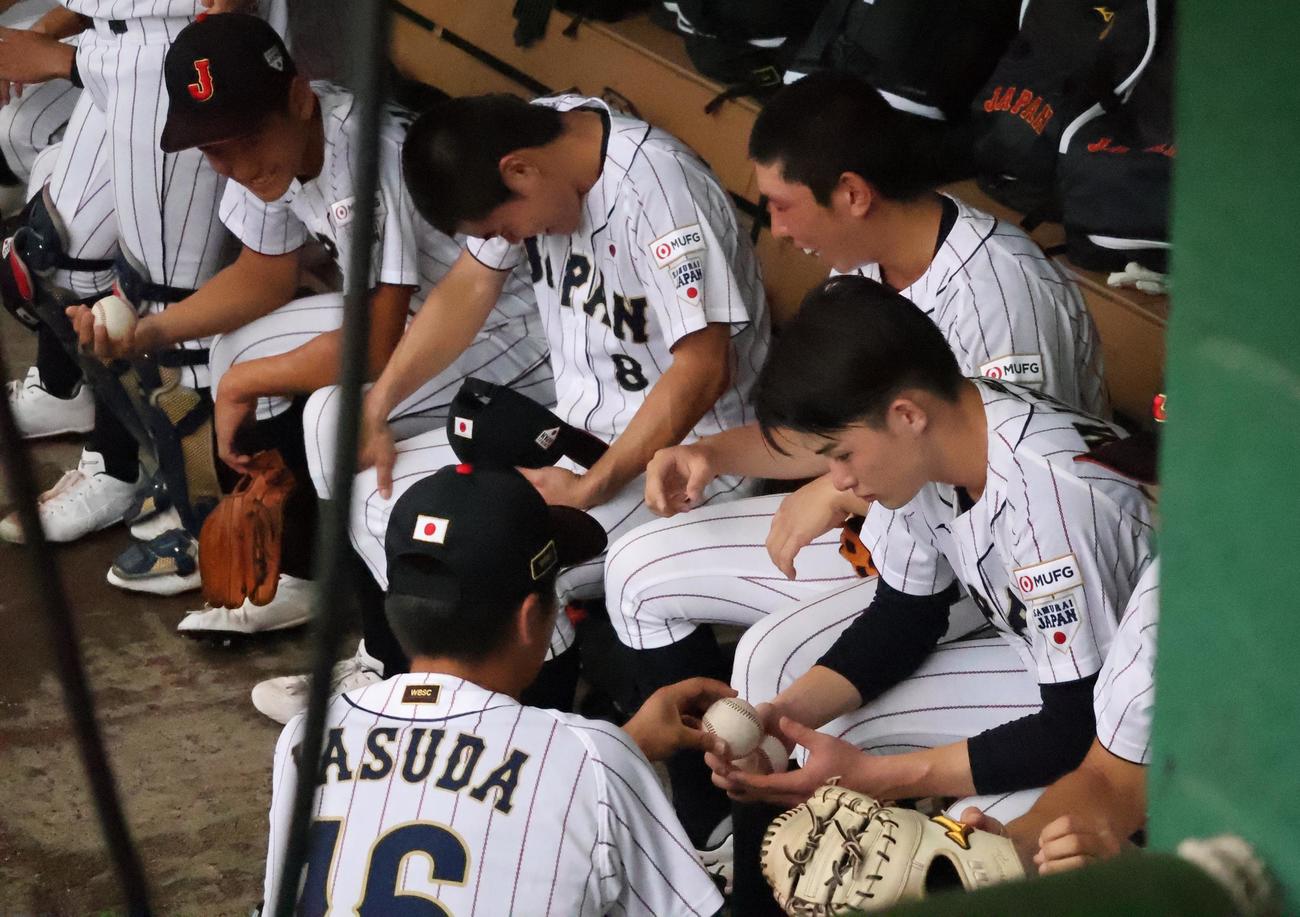 練習中に雨が降り、ベンチでボールの握りについて話す安田虎汰郎（手前）と丸田湊斗（撮影・柏原誠）