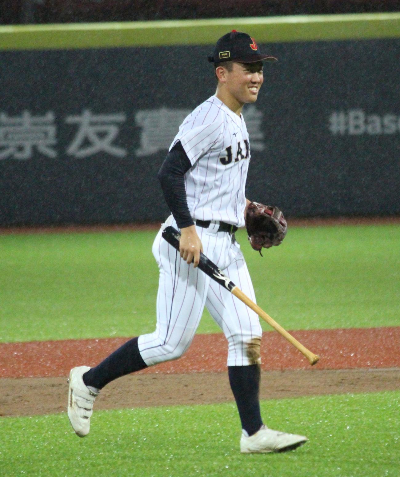 パナマ対日本　雨のためパナマ選手のバットが手から抜け、遊撃近くまで飛んできたため笑顔で持って行く小林（撮影・保坂恭子）