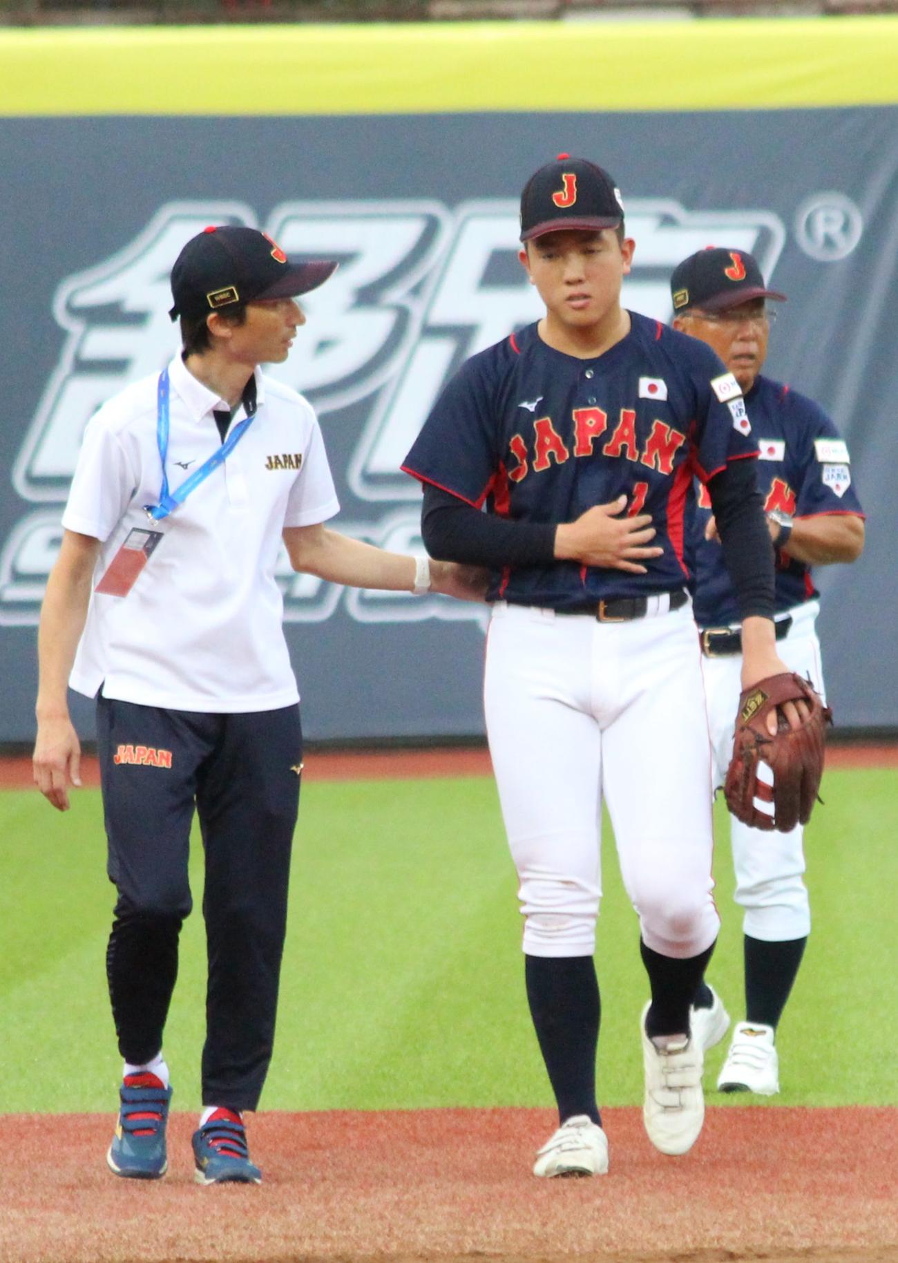 3日の日本対米国　4回裏米国無死、交錯プレーで倒れ込んだが、立ち上がっておなかを押さえる日本の小林（撮影・保坂恭子）