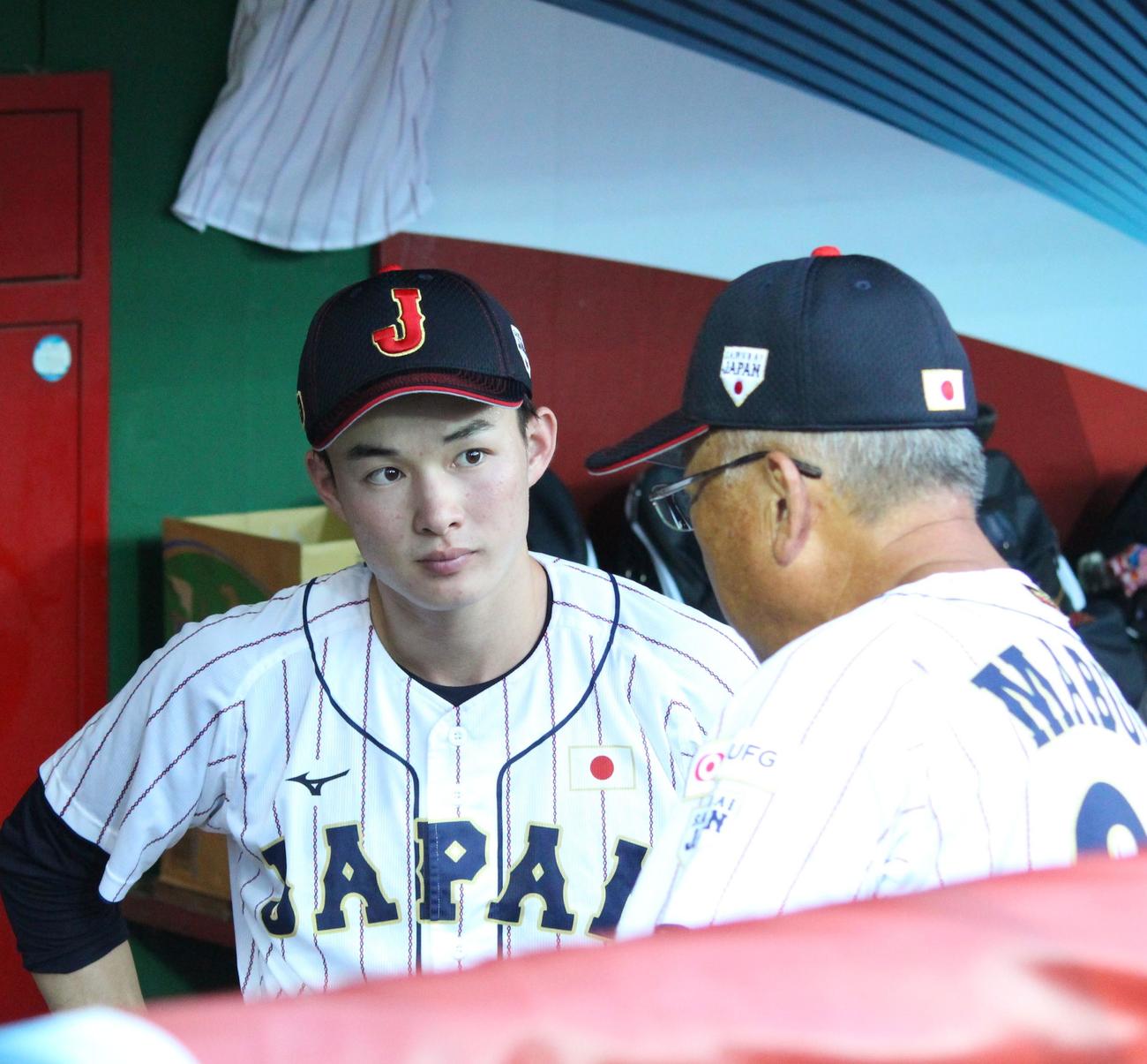 オランダ対日本　ベンチで馬淵史郎監督の話を聞く丸田（左）（撮影・保坂恭子）