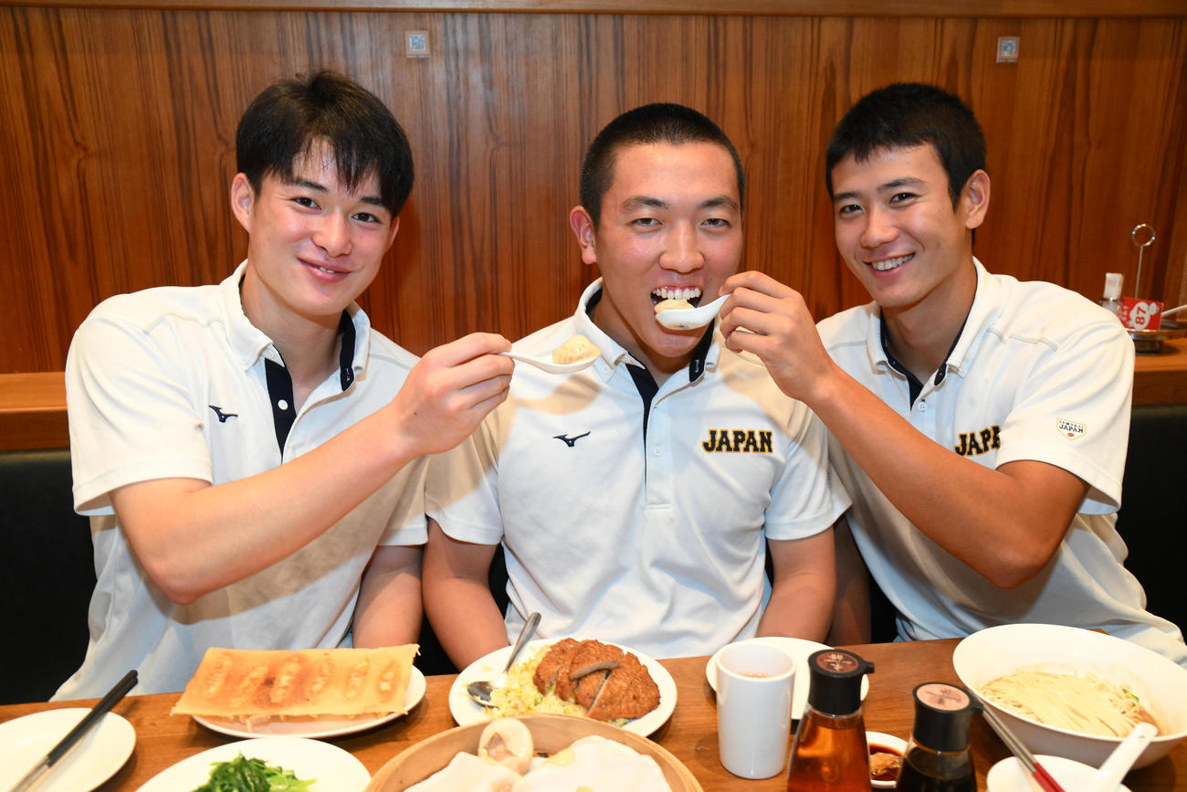 退院した小林主将（中央）に小籠包を「あーん」する丸田（左）と山田（右）（代表撮影）