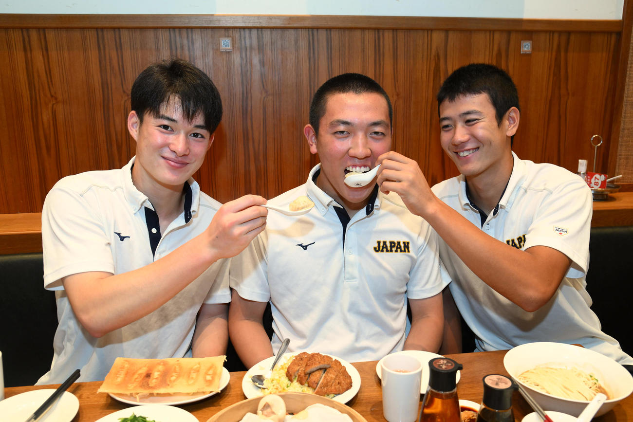 退院した小林主将（中央）に小籠包を「あーん」する丸田（左）と山田（右）（代表撮影）