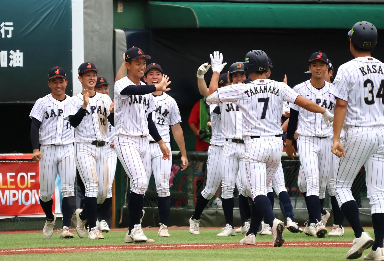 コールドを決める適時打を放った高中一樹を出迎える日本代表（撮影・柏原誠）