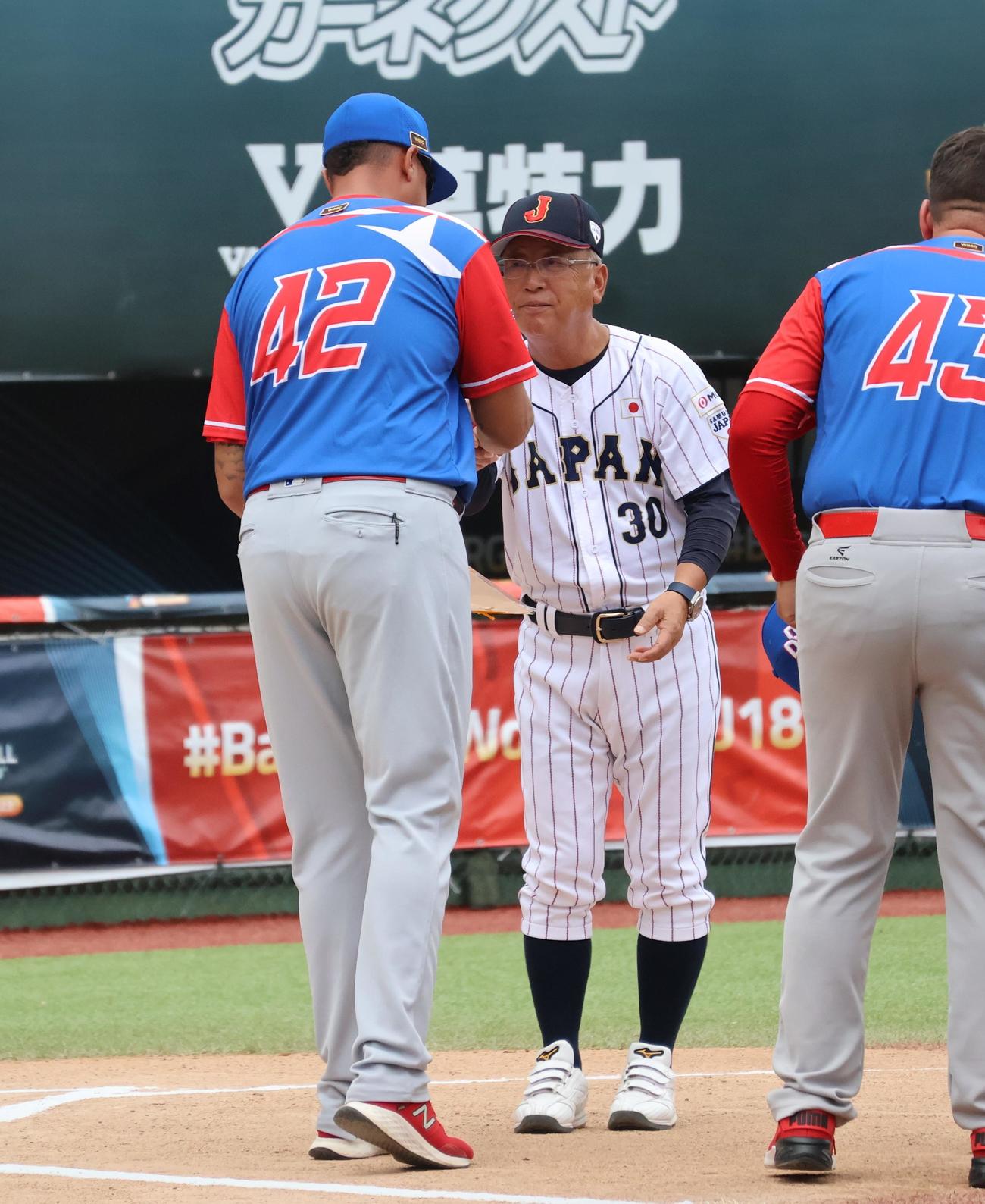 試合前に相手監督と握手をする日本・馬淵監督（撮影・柏原誠）