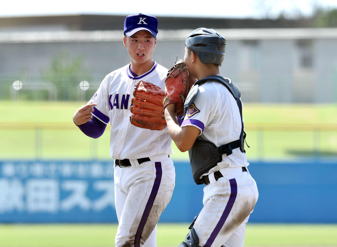 秋田対金足農　7回表終了後、金足農・相馬（右）と話しながらベンチに引き揚げる吉田（撮影・相沢孔志）