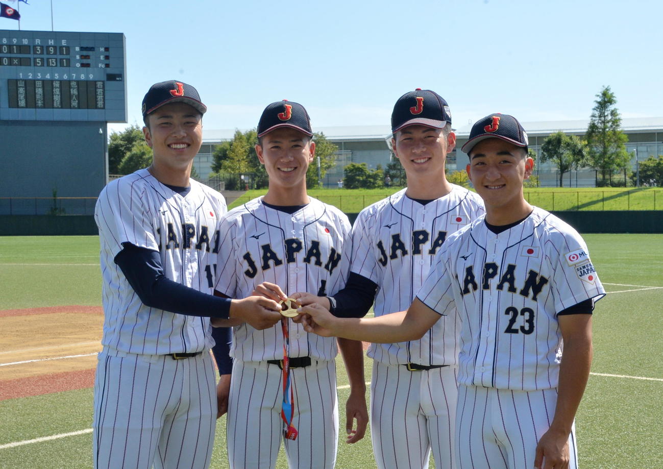 特別表彰を受けた侍ジャパンU18代表の左から高橋、山田、尾形、橋本は、山田のメダルを4人で持ち、笑顔で記念撮影（撮影・濱本神威）