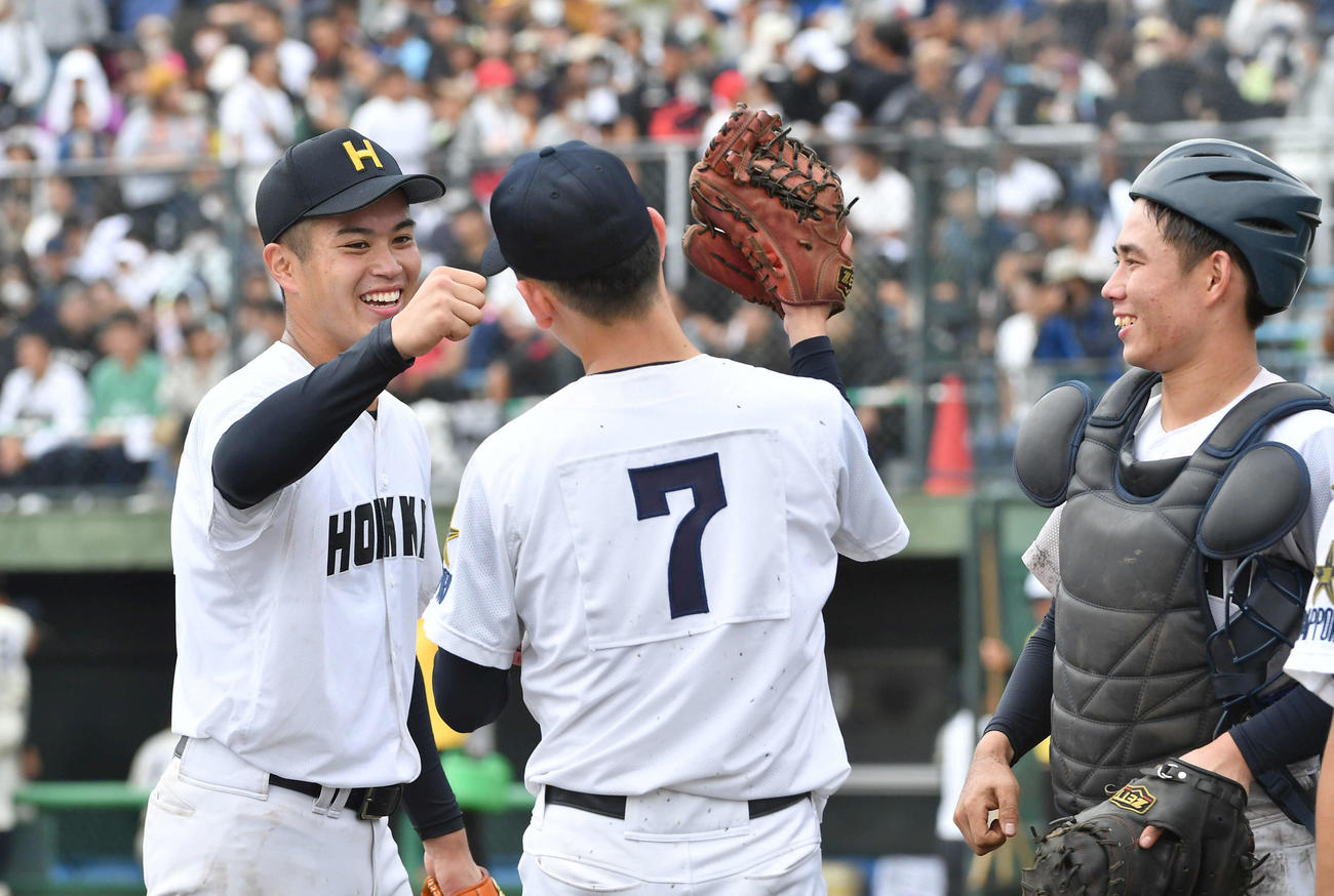神村学園対北海　神村学園に勝利し、長内（左から2人目）ら北海ナインと笑顔でタッチを交わす熊谷（撮影・岩下翔太）