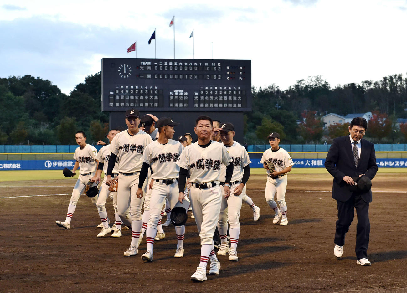 光南対一関学院　継続試合の末に初戦を突破した一関学院・高橋監督（中央）らナインはベンチに引き揚げる（撮影・相沢孔志）